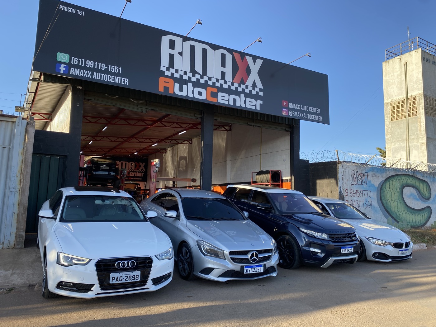 Fachada da RMAXX Auto Center com vários veículos premium